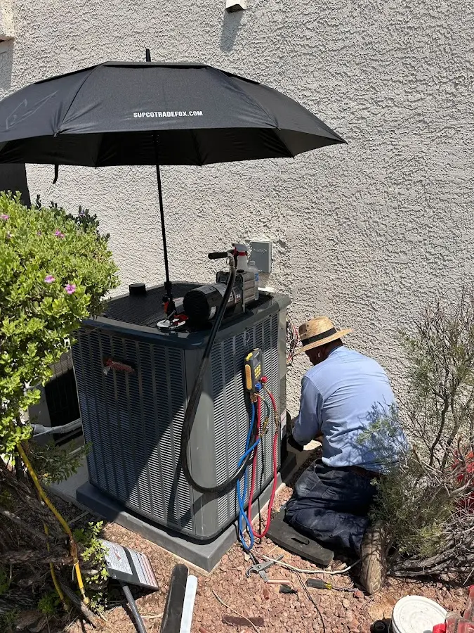 HVAC technician performing outdoor AC maintenance in Kimberly